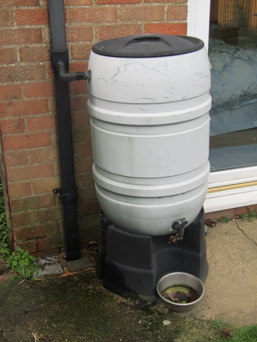 Regenton achter een woning voor het opvangen van regenwater.