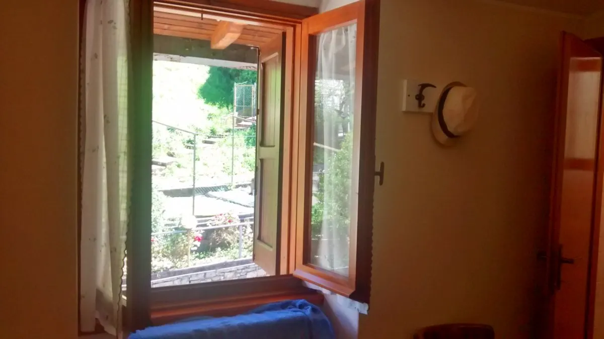 Uitzicht vanuit een hotelkamer door een open raam.