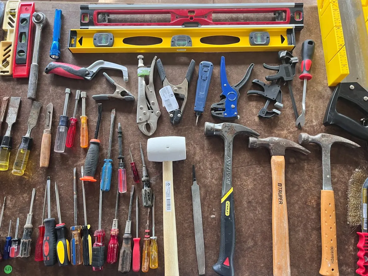 Handgereedschap voor reparaties ligt op een tafel.